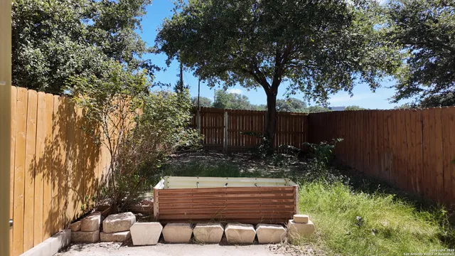 a view of garden with wooden bench