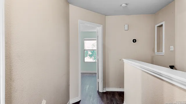 a hallway with closet and wooden floor