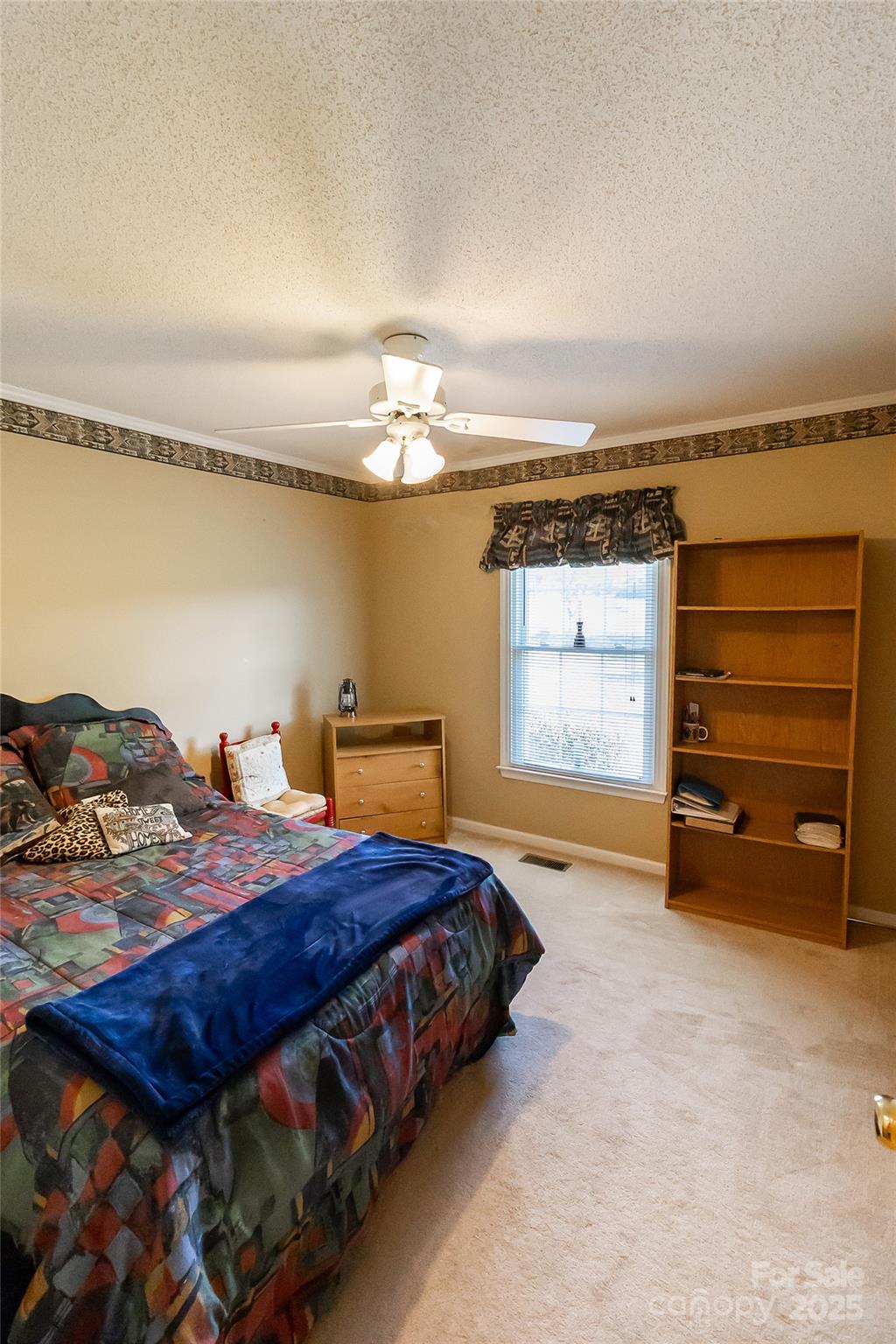 535 Holly Ridge Road Grover, NC 28073 - Photo 19 of 40 a bedroom with a bed and a chandelier