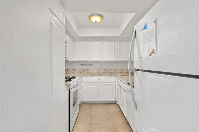 a kitchen with white cabinets and white appliances