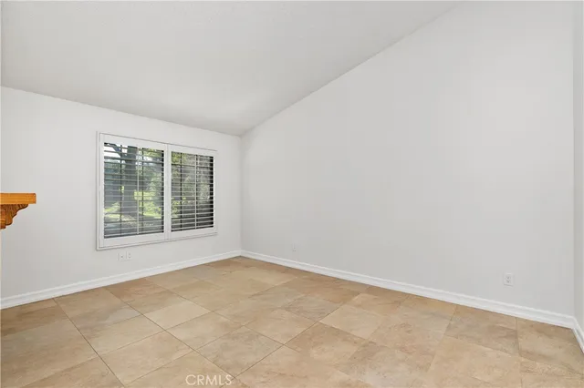 an empty room with a fireplace and a ceiling fan