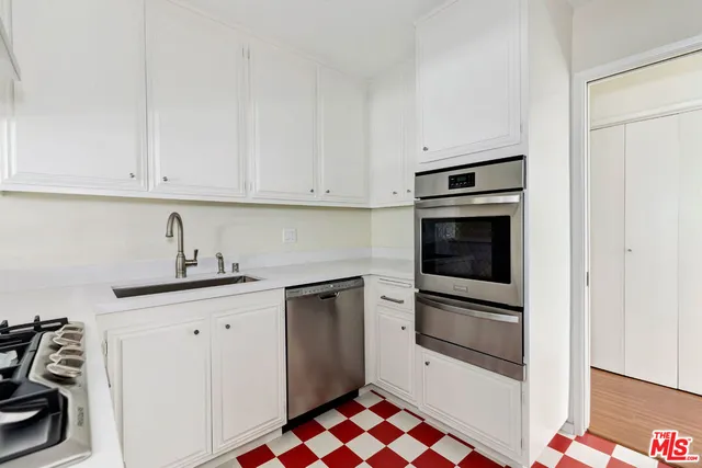 a kitchen with stainless steel appliances granite countertop a sink and a stove