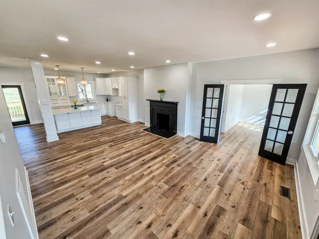 a large kitchen with kitchen island white cabinets and stainless steel appliances