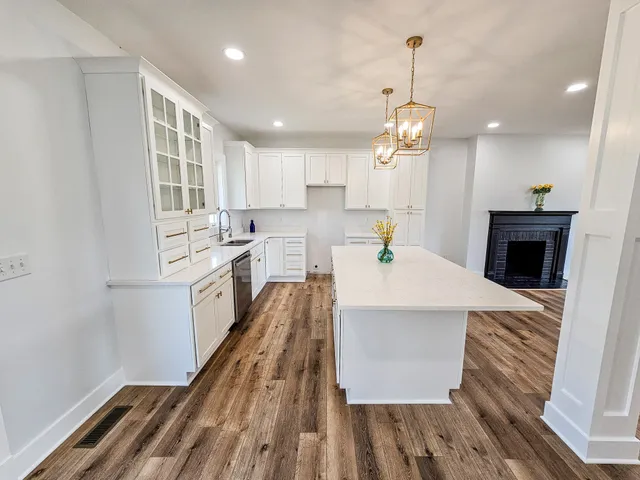 a view of a kitchen with granite countertop a sink white cabinets and counter space