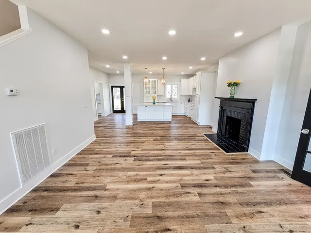 a large bedroom with wooden floor and a bed