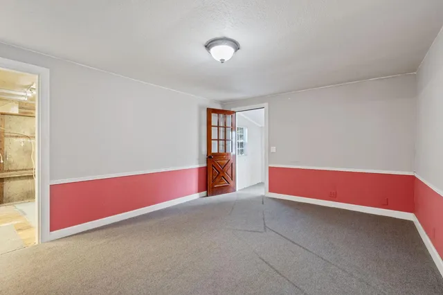 a view of empty room with air conditioner and windows