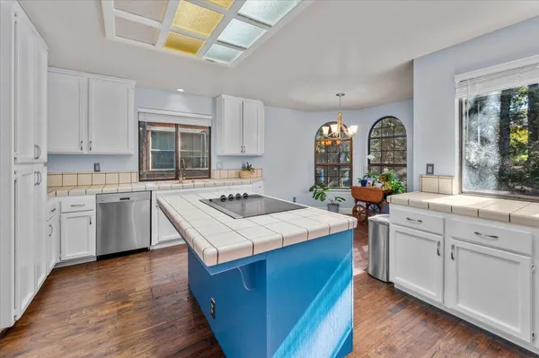 a kitchen with stainless steel appliances kitchen island granite countertop a stove and a sink