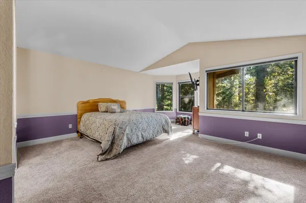 a spacious bedroom with a large bed and large windows