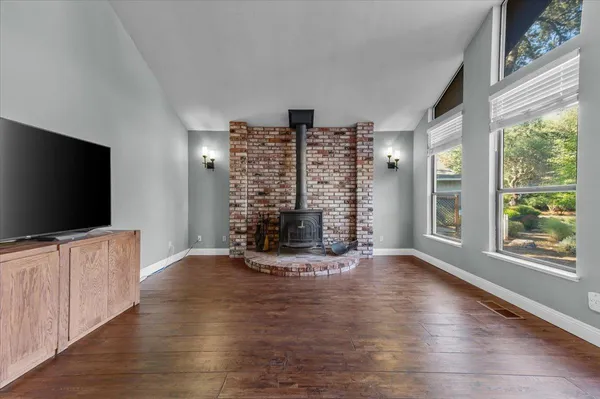 a view of an empty room with a window and wooden floor