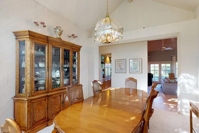 a dining room with furniture a chandelier and wooden floor