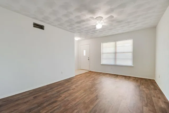 wooden floor in an empty room with a window