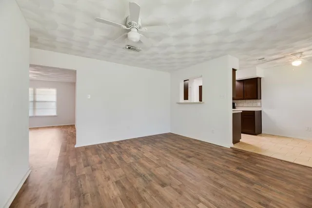 a view of empty room with wooden floor and fireplace