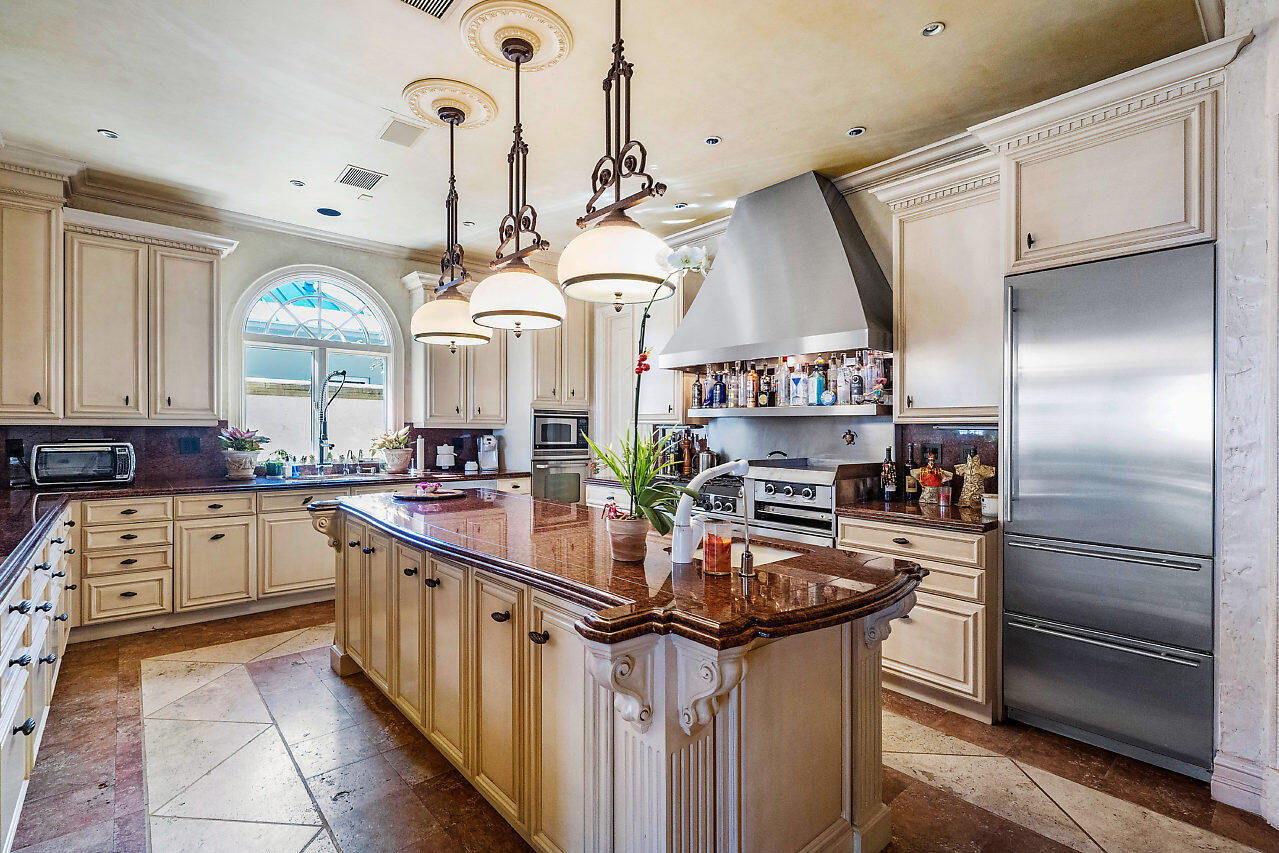 719 North Ocean Boulevard Delray Beach, FL 33483 - Photo 12 of 56 a kitchen with stainless steel appliances granite countertop a sink and cabinets