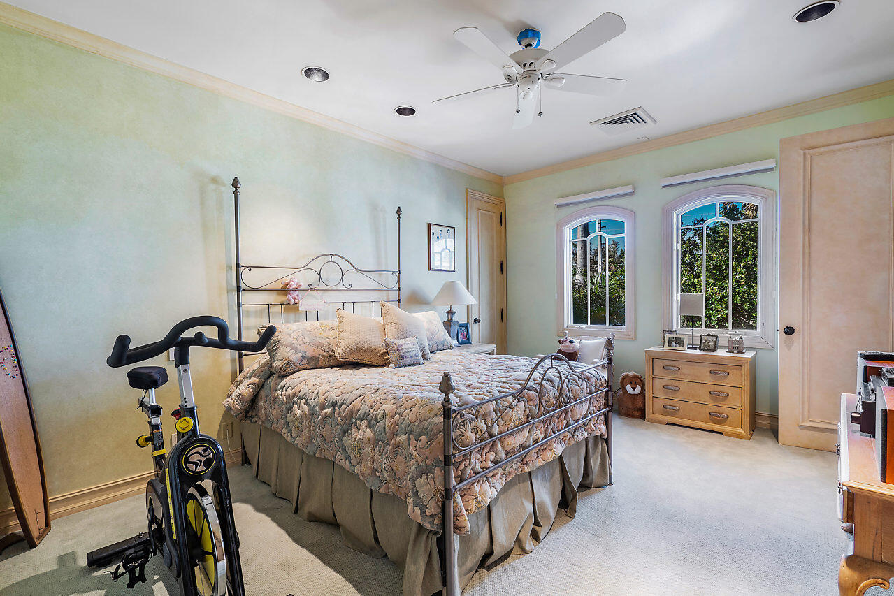 719 North Ocean Boulevard Delray Beach, FL 33483 - Photo 40 of 56 a bedroom with a bed and a chandelier