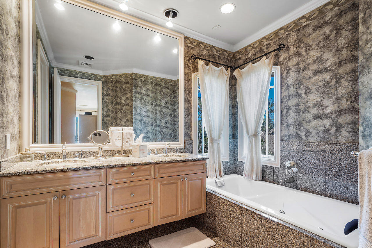 719 North Ocean Boulevard Delray Beach, FL 33483 - Photo 41 of 56 a bathroom with a granite countertop sink a toilet a mirror and bathtub