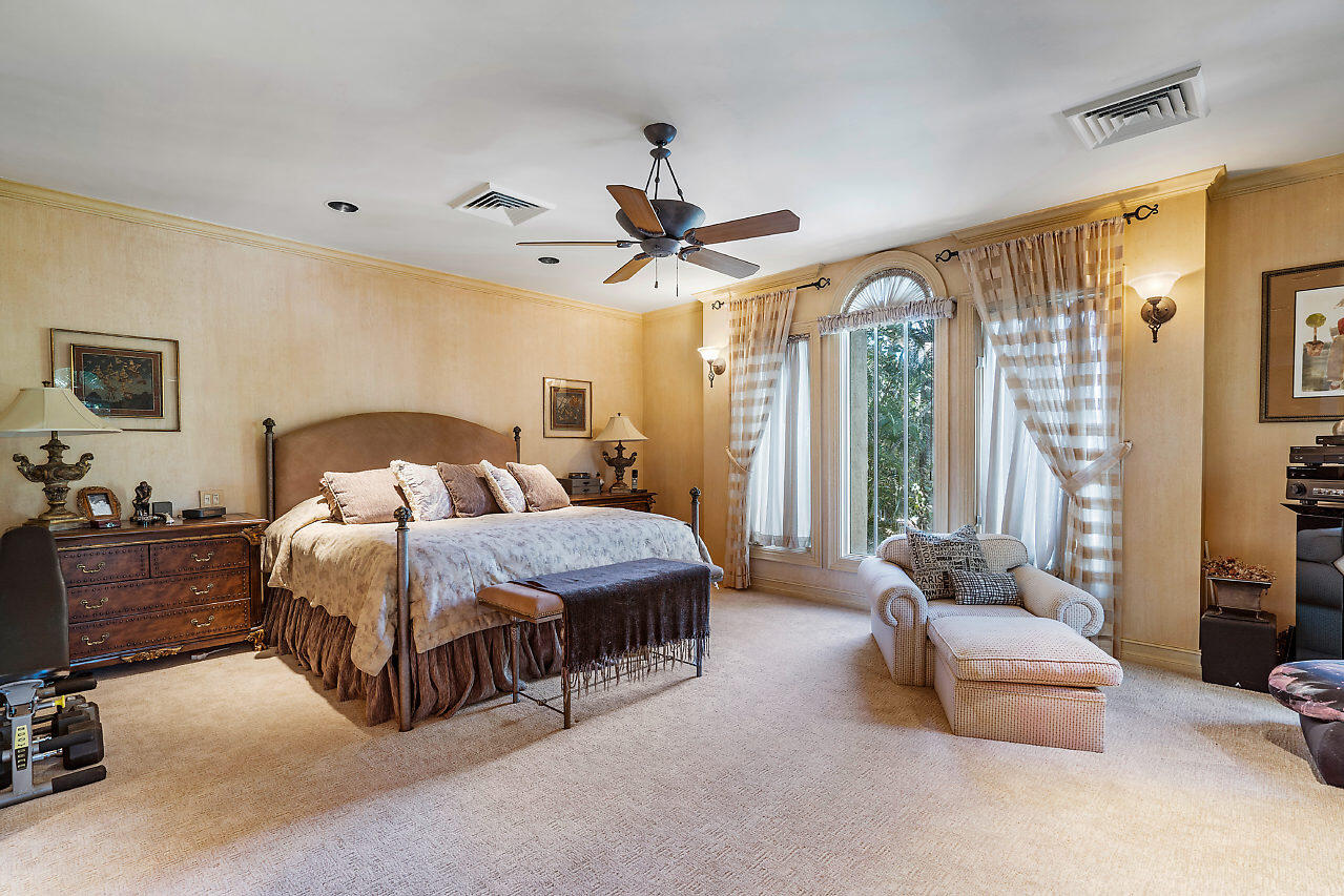 719 North Ocean Boulevard Delray Beach, FL 33483 - Photo 44 of 56 a spacious bedroom with a bed a couch and a chandelier