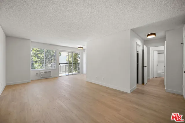 a view of a big room with wooden floor and windows