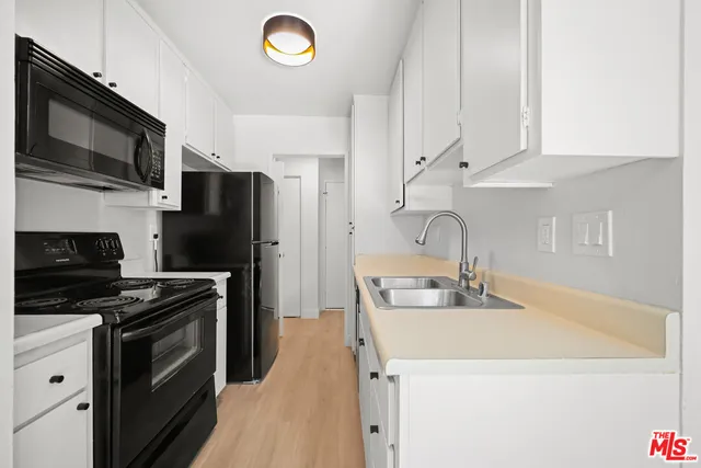 a kitchen with stainless steel appliances a stove microwave and sink