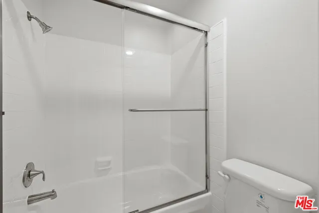 a bathroom with a granite countertop bathtub shower and toilet
