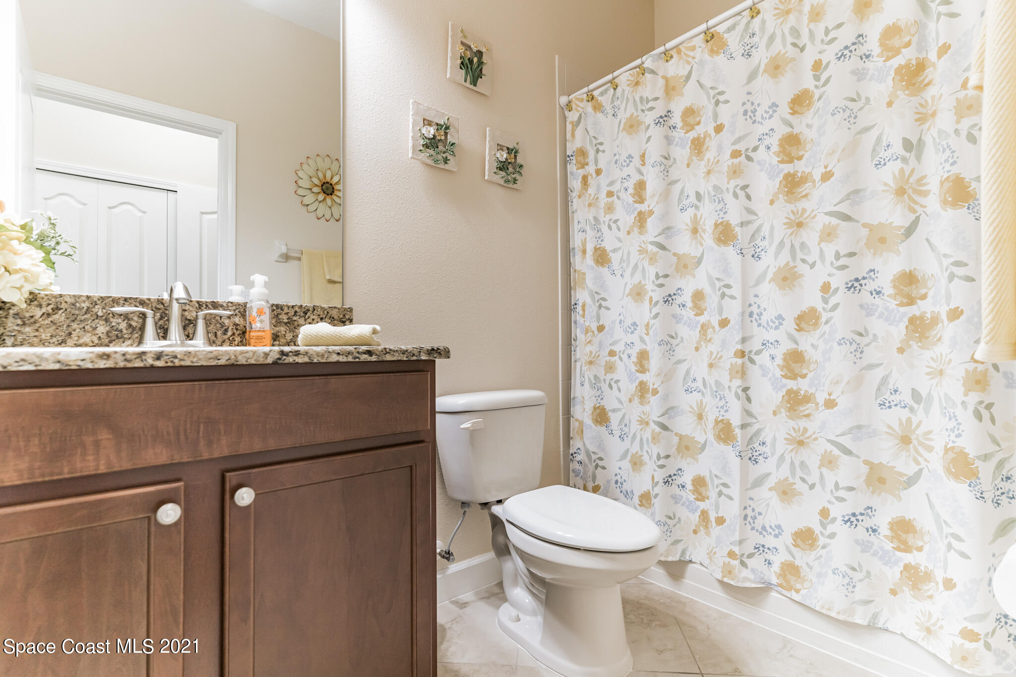 3242 Balboa Place Melbourne, FL 32940 - Photo 17 of 34 a bathroom with a sink a toilet and a mirror