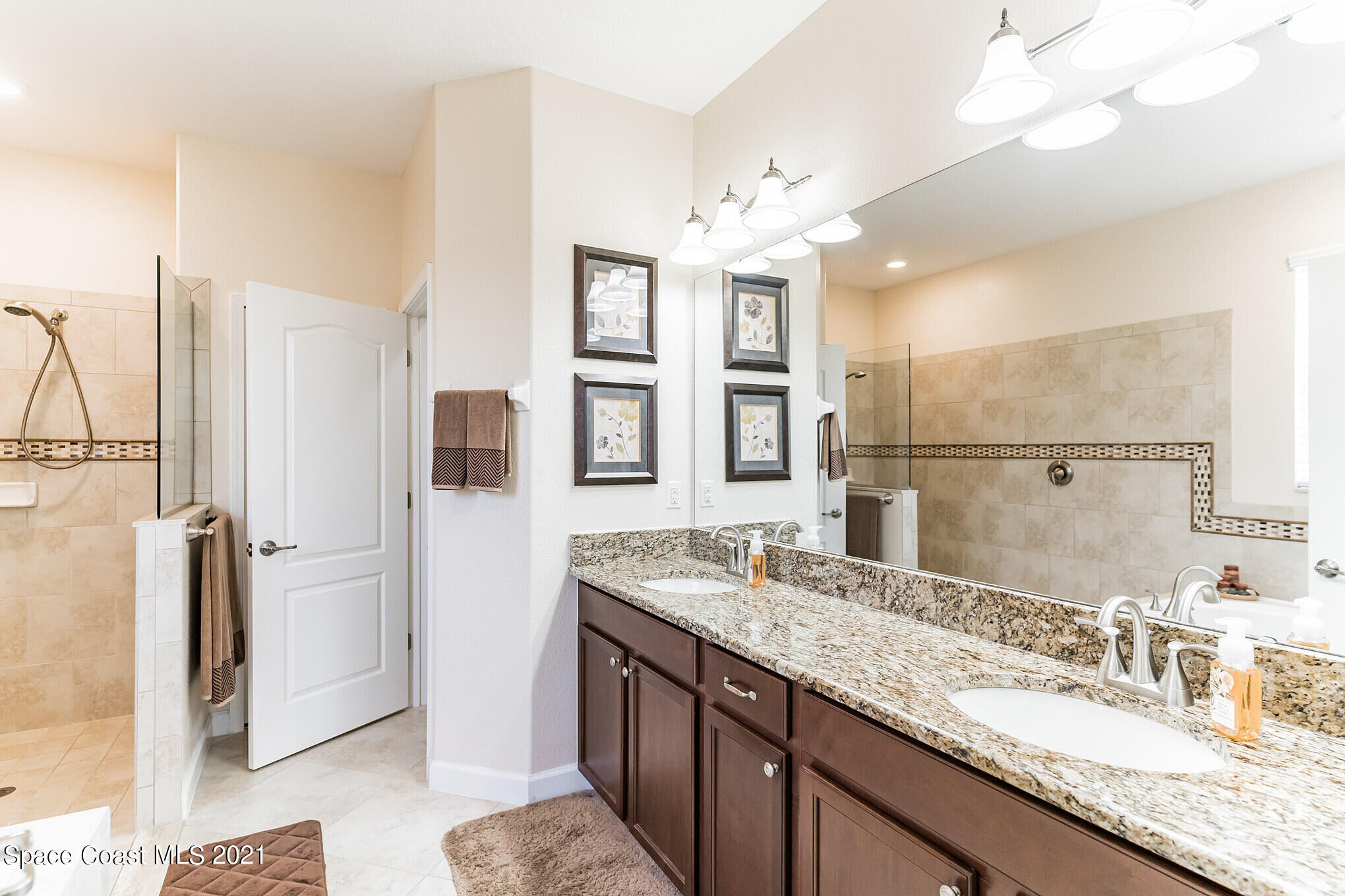 3242 Balboa Place Melbourne, FL 32940 - Photo 22 of 34 a bathroom with a granite countertop double vanity sink a shower and a mirror