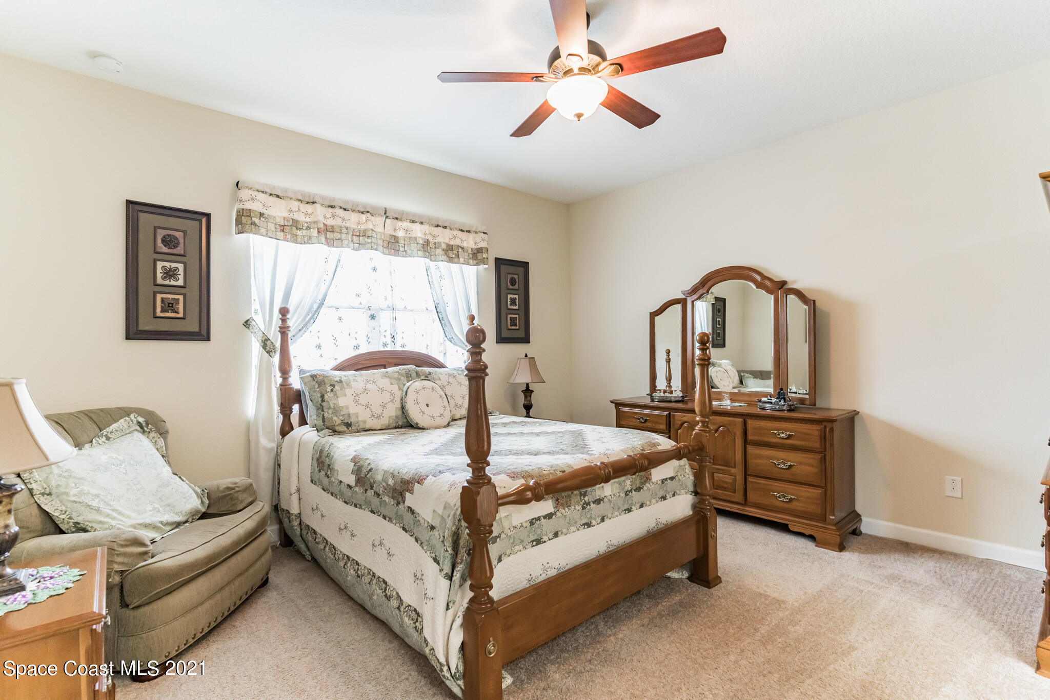 3242 Balboa Place Melbourne, FL 32940 - Photo 24 of 34 a bedroom with a bed and a chandelier