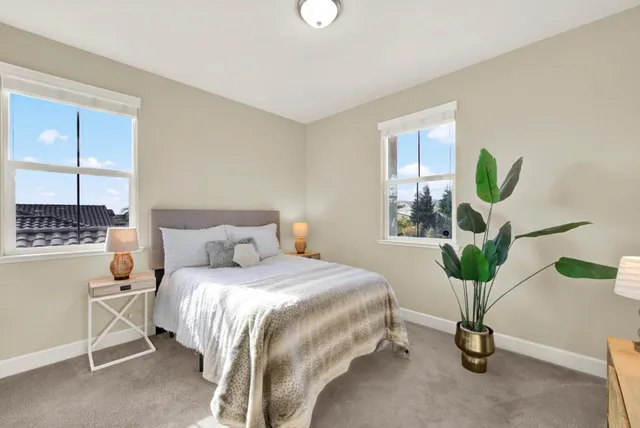 a bedroom with a bed and a potted plant