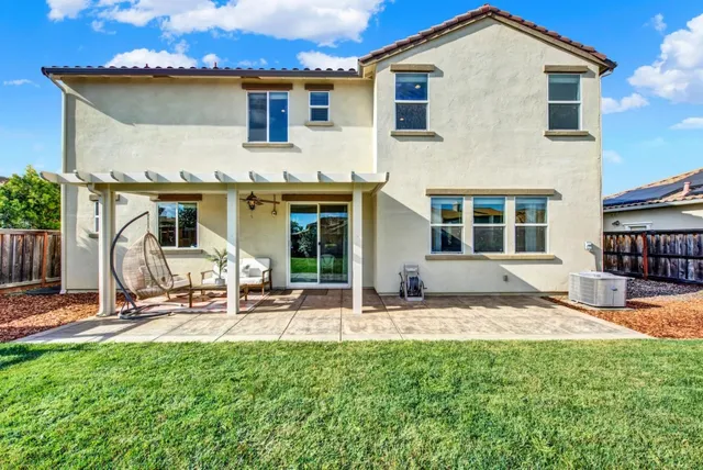 a view of a house with backyard and sitting area