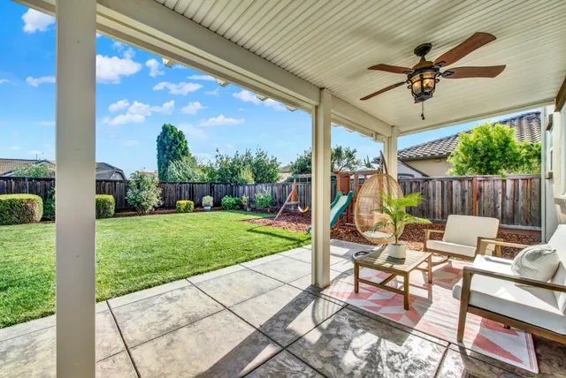 a view of a patio with a table chairs and a yard