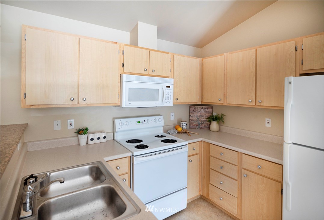 10709 Valley View Road, Unit A301 Bothell, WA 98011 - Photo 12 of 26 a kitchen with white cabinets sink and white appliances
