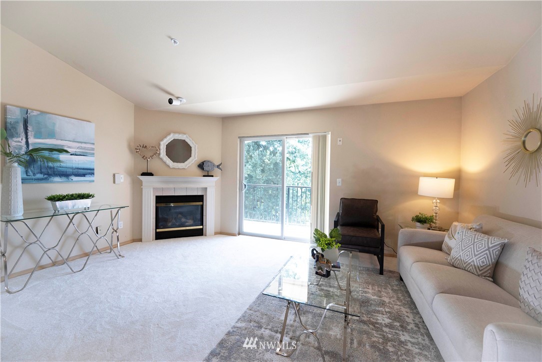 10709 Valley View Road, Unit A301 Bothell, WA 98011 - Photo 4 of 26 a living room with furniture a large window and a fireplace
