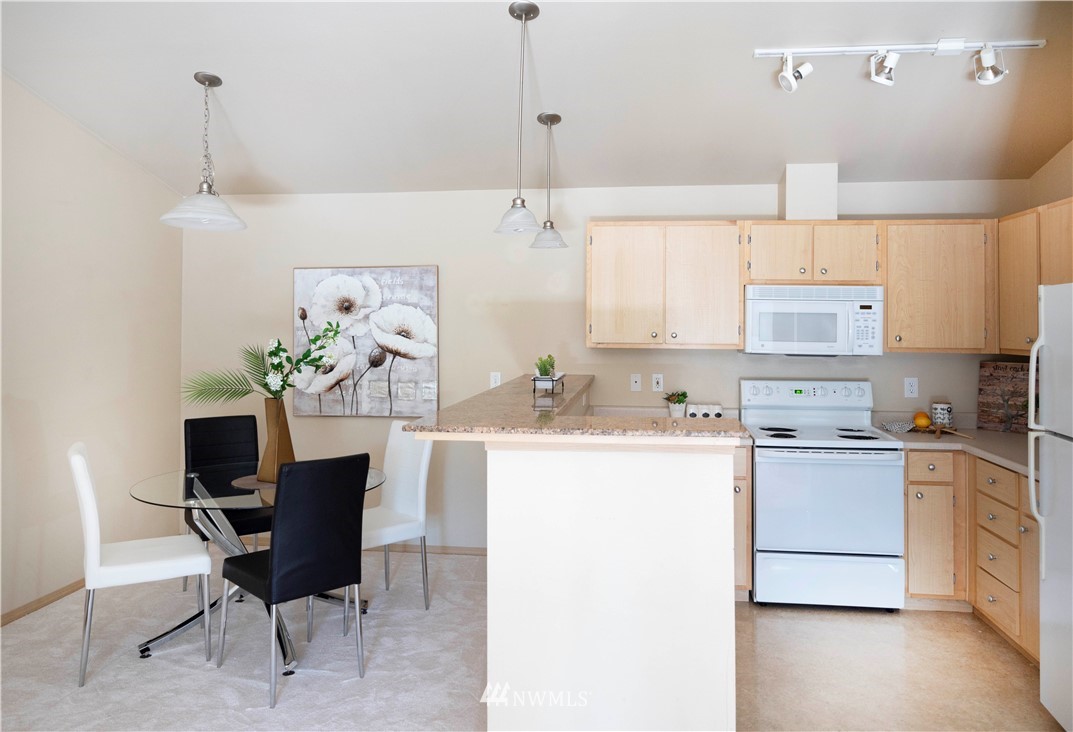 10709 Valley View Road, Unit A301 Bothell, WA 98011 - Photo 10 of 26 a kitchen with cabinets a sink and a stove