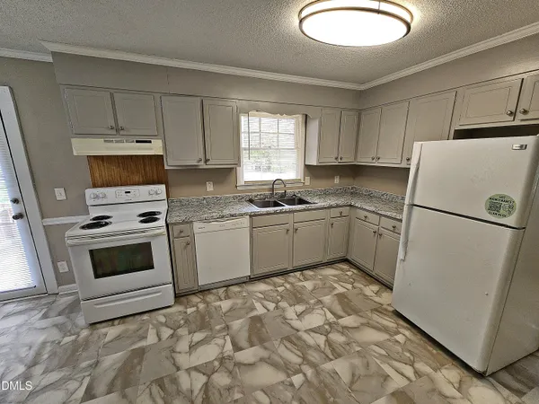 a kitchen with a stove a refrigerator and a sink