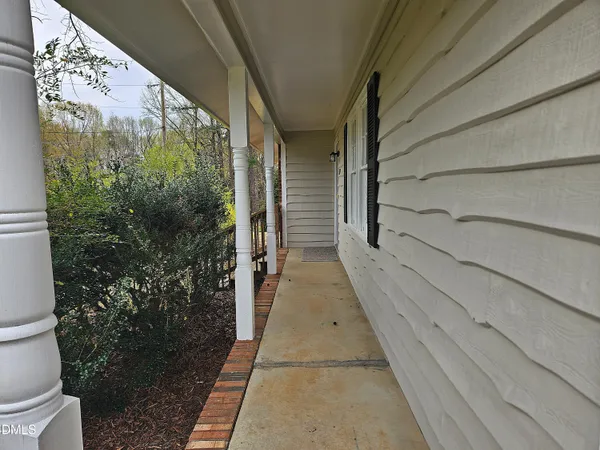 a view of a house with a yard and large tree