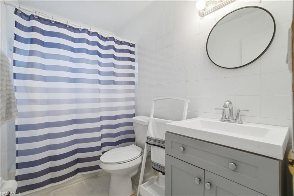 55 2nd Street Bonita Springs, FL 34134 - Photo 17 of 25 a bathroom with a sink a toilet and a mirror