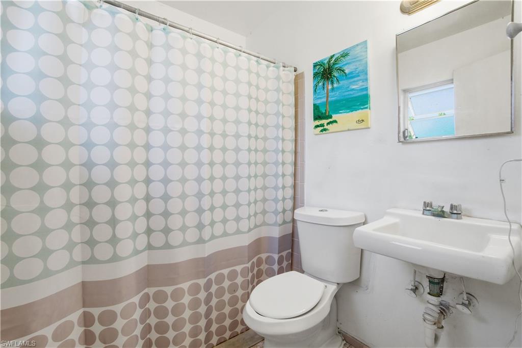 55 2nd Street Bonita Springs, FL 34134 - Photo 19 of 25 a bathroom with a sink a toilet and a mirror