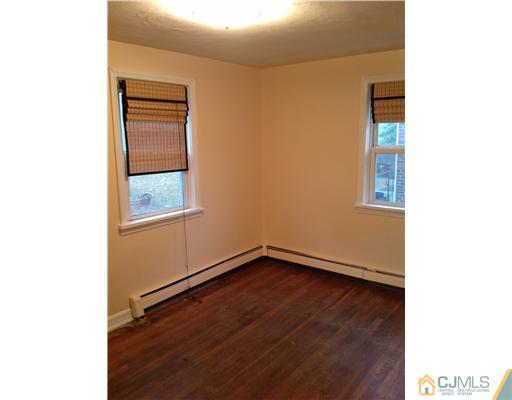 824 2nd Street, Unit 1 Dunellen, NJ 08812 - Photo 4 of 11 a view of an empty room with wooden floor and a window