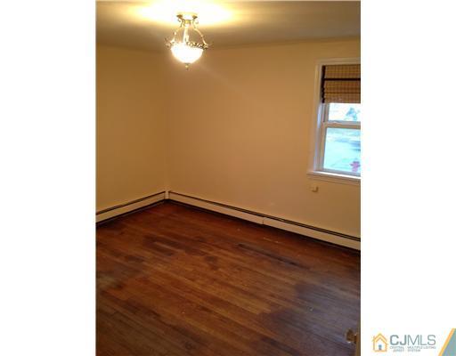 824 2nd Street, Unit 1 Dunellen, NJ 08812 - Photo 6 of 11 a view of an empty room with wooden floor and a window