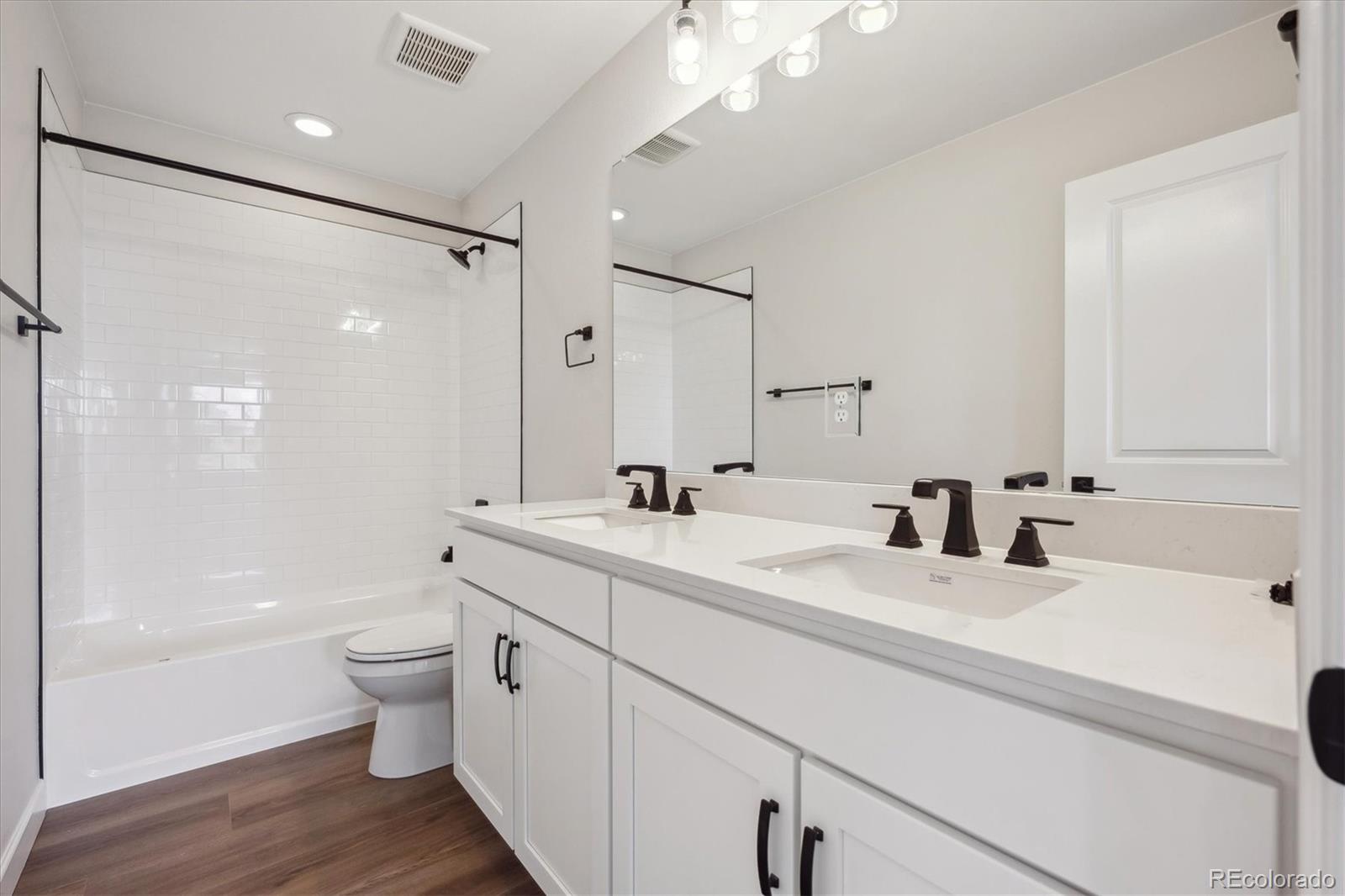 5583 Riverbend Avenue Firestone, CO 80504 - Photo 16 of 25 a bathroom with a double vanity sink toilet mirror and shower