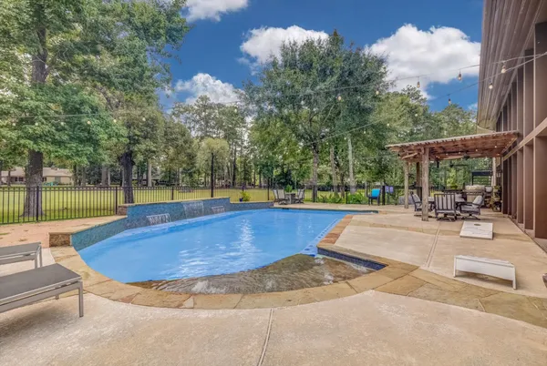 a view of a swimming pool with a patio and a yard