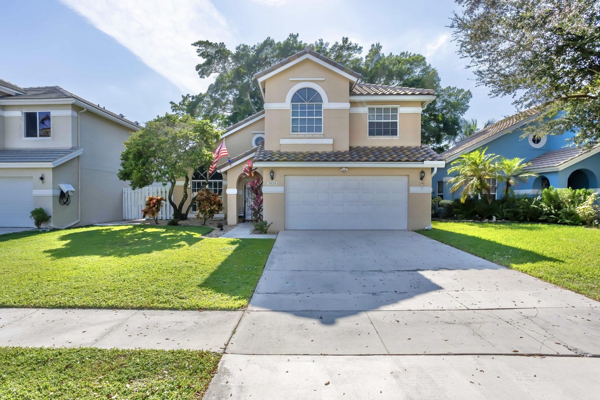 7424 Ashley Shores Circle Lake Worth, FL 33467 - Photo 1 of 33 a front view of house with yard and green space