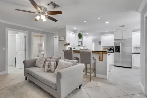 a living room with stainless steel appliances kitchen island granite countertop furniture and a view of kitchen