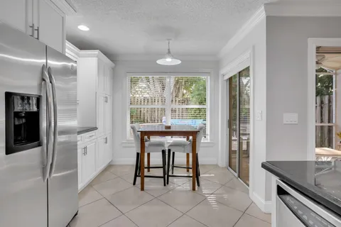 a kitchen with a table chairs refrigerator and microwave