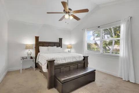 a bed room with a bed and a ceiling fan