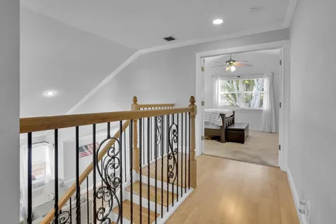a view of a hallway with wooden floor and stairs