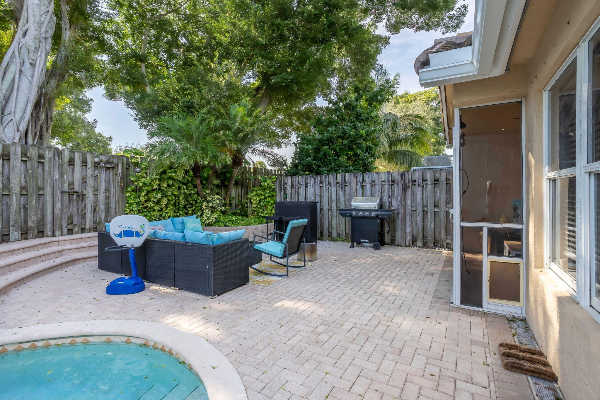 7424 Ashley Shores Circle Lake Worth, FL 33467 - Photo 31 of 33 a backyard of a house with barbeque oven and outdoor seating