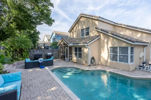 a front view of a house with swimming pool and sitting area