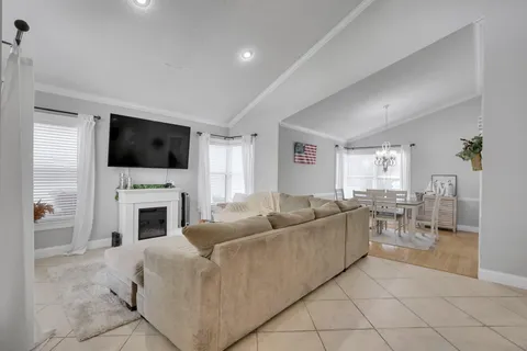 a living room with furniture a fireplace and a flat screen tv