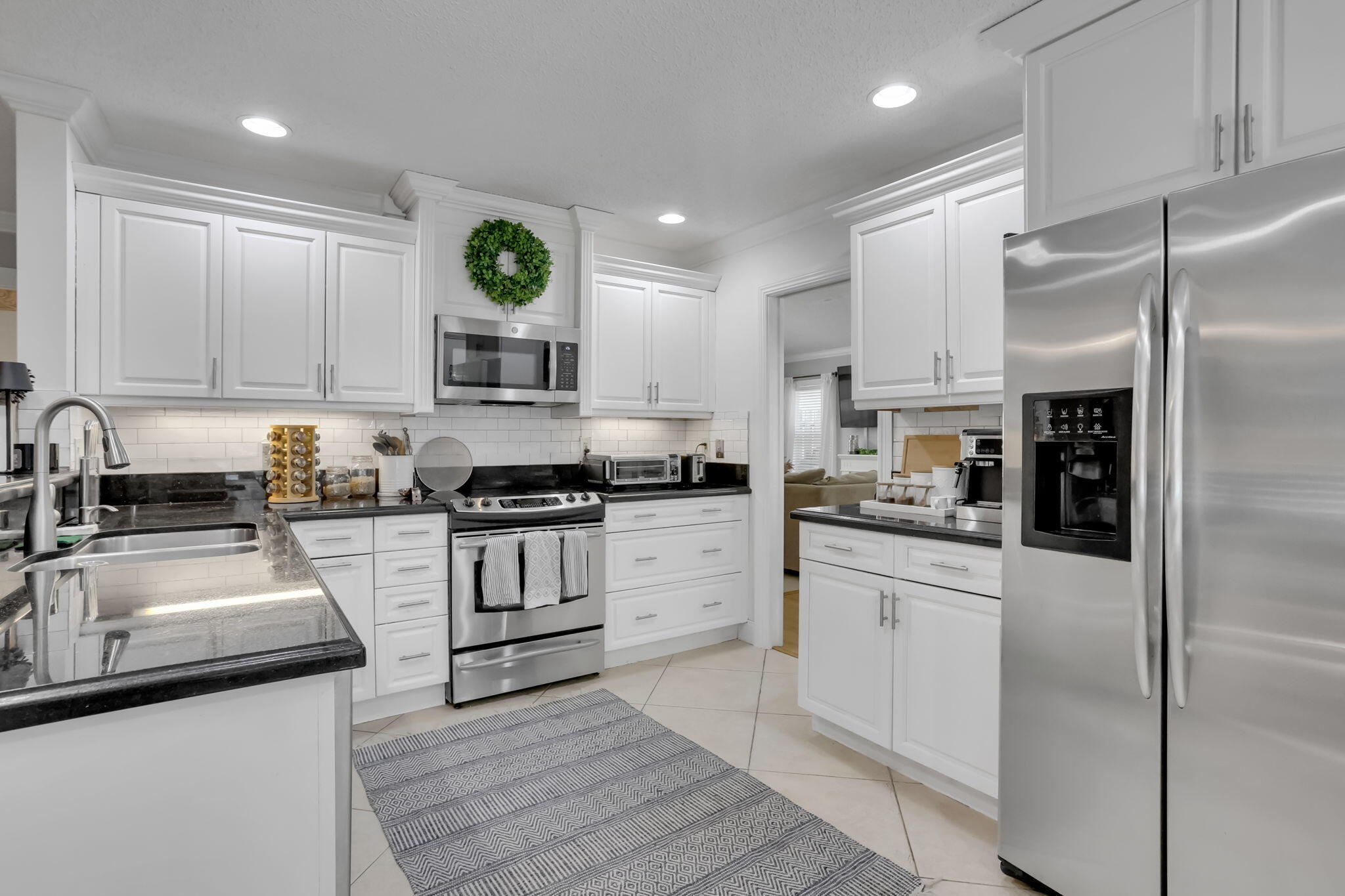 7424 Ashley Shores Circle Lake Worth, FL 33467 - Photo 10 of 33 a kitchen with granite countertop stainless steel appliances and wooden cabinets