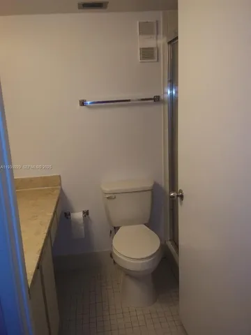 a white toilet sitting next to a shower